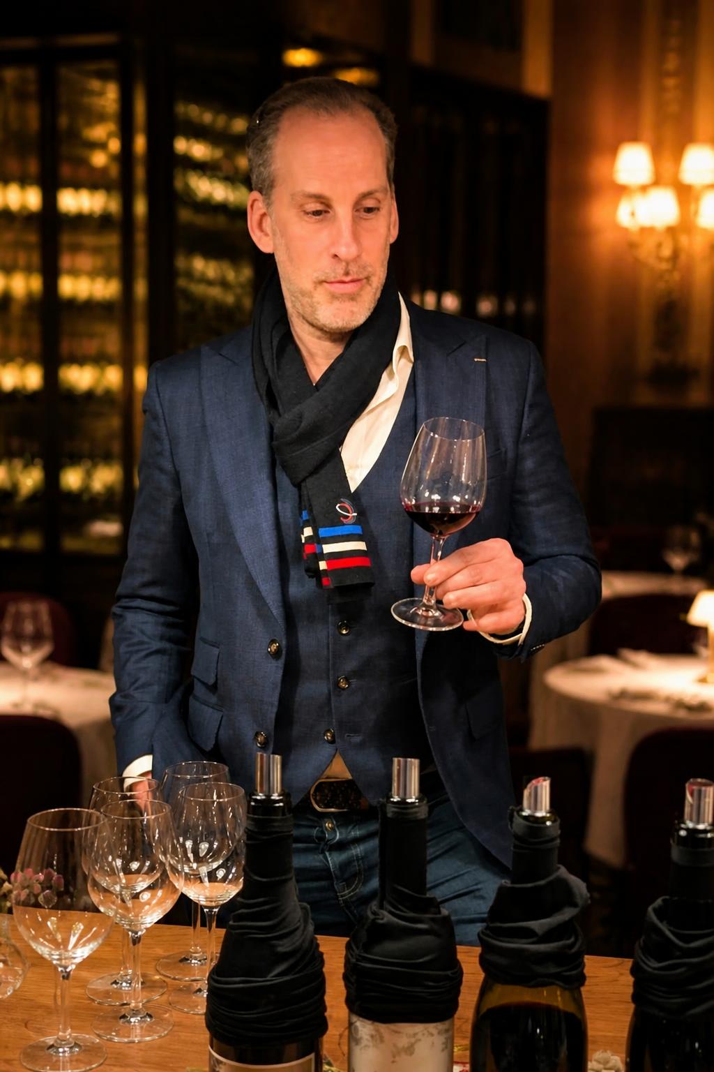 Emmanuel Delmas, sommelier et formateur de L'Académie™, observe un verre de vin rouge lors d'une dégustation